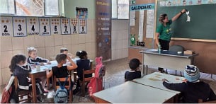 Eunice geeft les aan een groep kinderen in de klas