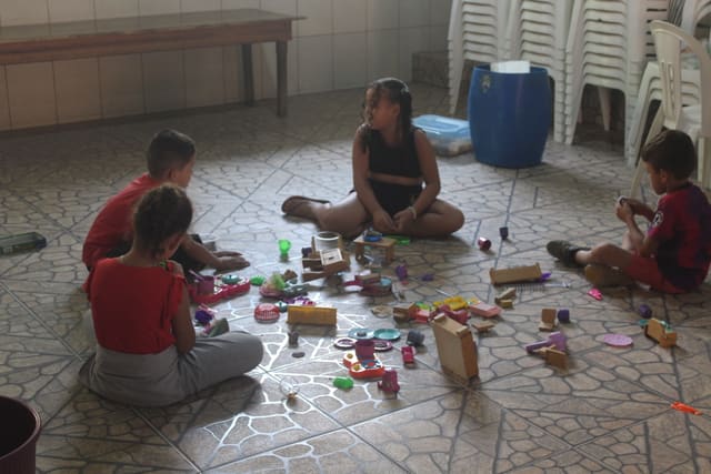 Kinderen spelen samen op de grond met speelgoed