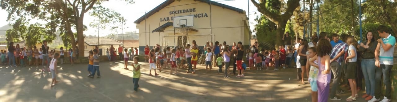 Een grote groep kinderen op het terrein van de Lar da Infância in Brazilië